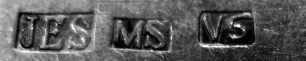 Esimerkkejä MS-merkinnästä hopeanvärisessä metalliesineessä